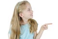 Photo of happy little girl standing isolated over white wall background. Looking side showing copyspace pointing. Royalty Free Stock Photo