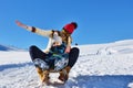 Photo of happy mother and child playing in the snow with a sledge in a sunny winter day Royalty Free Stock Photo