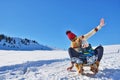 Photo of happy mother and child playing in the snow with a sledge in a sunny winter day Royalty Free Stock Photo