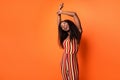 Photo of happy nice pretty afro american young lady raise hands dancer isolated on orange color background
