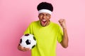 Photo of happy positive dark skin man winner match hold football player isolated on pink color background