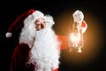 Photo of happy Santa Claus with a lantern of Christmas present in hands, isolated on black background Royalty Free Stock Photo