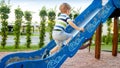 Image of happy smiling cheerful toddler boy riding and climbing on the big children playground at park Royalty Free Stock Photo