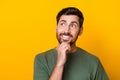 Photo of happy smiling guy dressed green t-shirt am chin looking empty space isolated yellow color background Royalty Free Stock Photo