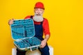 Photo of happy smiling old guy dressed uniform overall red hardhat showing tools holder empty space isolated yellow