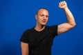 Photo of happy victorious young man raise hand celebrate raise fist isolated on blue color background. Winner concept.