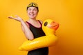 Photo of happy woman in bathing suit with life preserver on empty orange background Royalty Free Stock Photo