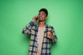 Photo of happy young african man talking by mobile phone isolated over green wall background Royalty Free Stock Photo