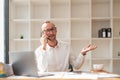 Photo of happy young businessman using laptop computer and talking on smartphone in office Royalty Free Stock Photo