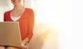 Happy young businesswoman with laptop sitting on chair in office lobby Royalty Free Stock Photo