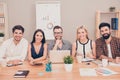 Photo of happy young team of businesspeople sitting at conference table smiling Royalty Free Stock Photo