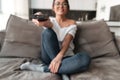 Happy young woman sitting on sofa at home watch TV. Royalty Free Stock Photo