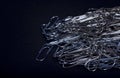 Heap of metal note paper clips on dark background, High details with high contrast