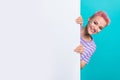 Photo of hiding banner empty space young woman pink dyed haircute wearing striped purple t shirt isolated on aquamarine Royalty Free Stock Photo