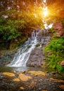 Photo of high waterfall in the mountains with sun