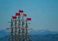 Photo of high wooden masts of old ships in port against blue sky and mountains at evening Royalty Free Stock Photo