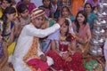 A photo of a Hindu wedding in which the groom fills vermilion in demand of his bride.