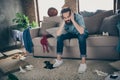 Photo of hipster crazy guy sitting sofa holding head intoxicated food underwear lying floor had stag party suffer Royalty Free Stock Photo