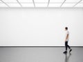 Photo of hipster in modern gallery looking at the empty canvas. Blank mockup, motion blur Royalty Free Stock Photo