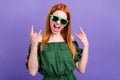 Photo of horned funky young woman dressed off-shoulders blouse dark eyewear showing hard rock sign isolated violet color Royalty Free Stock Photo