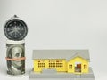 Photo of house miniature with dollar bills and compass isolated on white background. Royalty Free Stock Photo