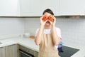 Photo of housewife attractive lady arms holding two big tomato hiding eyes playful mood enjoy morning cooking tasty dinner wear Royalty Free Stock Photo