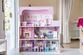 The photo of huge pink dollhouse model furnished with miniature furniture in a kidÃ¢â¬â¢s room
