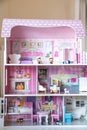 The photo of huge pink dollhouse model furnished with miniature furniture in a kidÃ¢â¬â¢s room