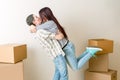Photo of hugging men and women among cardboard boxes