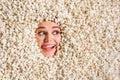 Photo of hungry dreamy young woman face showing stick out curious peeking hole covered tasty caramel popcorn