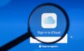 Photo of icloud homepage on a iMac monitor screen through a magnifying glass.