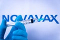 In this photo illustration a hand in medical gloves holds a syringe in front of Novavax logo in Barcelona, Spain on September 2, 2
