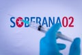 In this photo illustration a hand in medical gloves holds a syringe in front of Soberana 02 vaccine logo in Barcelona, Spain on Se