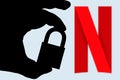 In this photo illustration a man holds a padlock and in the background the logo of Netflix on the computer screen. Online data