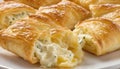 Photo illustration of plate of flaky puff pastries filled with soft and creamy cheeses