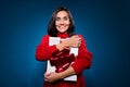 Photo of impressed brown hair lady hug present wear red sweater isolated on blue color background Royalty Free Stock Photo