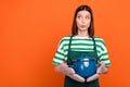 Photo of impressed brunette young lady cook look promo wear striped t-shirt apron isolated on orange color background
