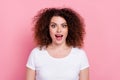 Photo of impressed ecstatic woman with perming coiffure dressed white t-shirt staring at awesome offer isolated on pink