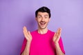 Photo of impressed excited young guy dressed pink t-shirt rising arms open mouth isolated violet color background