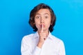 Photo of impressed funny schoolboy wear formal clothes finger lips asking keep silence blue color background