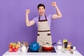 Photo of impressed lucky boyfriend dressed chef outfit cooked delicious dinner rising fists isolated purple color