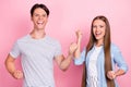 Photo of impressed lucky young lovers dressed casual outfits rising fists smiling isolated pink color background