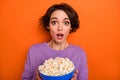 Photo of impressed nice lady hold big plate popcorn open mouth look camera isolated on orange color background