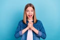 Photo of impressed small blond girl hold arms wear jeans shirt isolated on blue color background Royalty Free Stock Photo