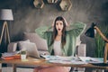 Photo of impressed stress brunette girl work from home papers arms head wear green shirt trousers indoors Royalty Free Stock Photo