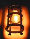 Photo of an incandescent lamp light on in rustic support.