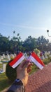 Photo of the Indonesian flag on Indonesian Independence Day with the graves of the heroes in the background