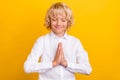 Photo of inspired schoolboy close eyes hold palms plead wear school uniform isolated yellow color background