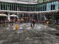 photo of interaction between children and parents playing in a fountain at a mall, looks happy and excited