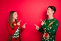 Photo of interested two friends indicate finger empty space wear ugly pullover isolated red color background Royalty Free Stock Photo